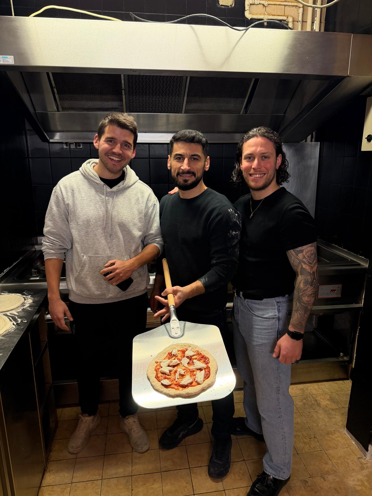 Max, Serdon und Fabio gemeinsam mit ihrer Pizza am Ofen